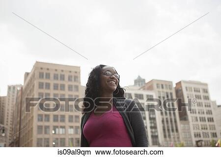 Low angle portrait of smiling woman, Detroit, Michigan, USA View Large Photo Image Picture - Low angle portrait of smiling woman, Detroit, Michigan, USA. Fotosearch