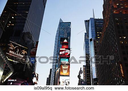 Stock Photography - Low angle view of skyscrapers and advertising signs at sunset, New York, USA. Fotosearch