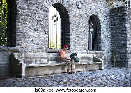 Male student sitting on bench using laptop View Large Photo Image Stock Image - Male student sitting on bench using laptop. Fotosearch