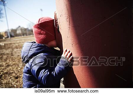 Male toddler playing hide and seek in park View Large Photo Image Picture - Male toddler playing hide and seek in park. Fotosearch