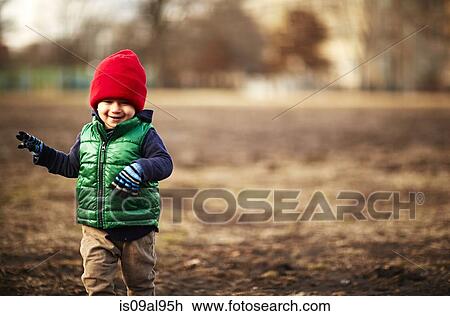 Stock Image - Male toddler running in park. Fotosearch