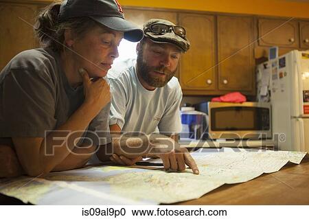 Man and woman studying map of USA at kitchen table View Large Photo Image Stock Image - Man and woman studying map of USA at kitchen table. Fotosearch