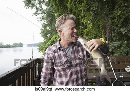 Man sticking out tongue at catfish, river Raisin, Monroe, Michigan, USA View Large Photo Image Stock Image - Man sticking out tongue at catfish, river Raisin, Monroe, Michigan, USA. Fotosearch