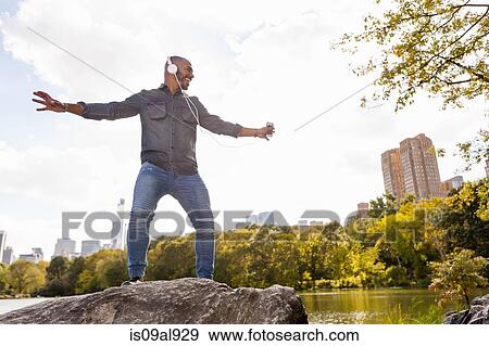 Man wearing earphones dancing, Central Park, New York, USA View Large Photo Image Stock Photo - Man wearing earphones dancing, Central Park, New York, USA. Fotosearch