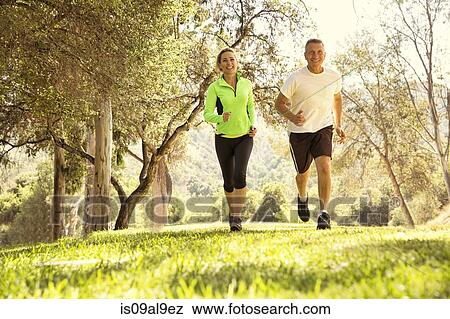 Mature couple running through park View Large Photo Image Stock Photo - Mature couple running through park. Fotosearch