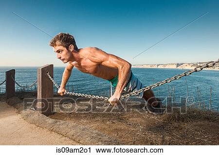 Mid adult man doing push up on chain rope View Large Photo Image Stock Image - Mid adult man doing push up on chain rope. Fotosearch