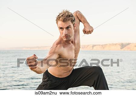 Mid adult man on beach in kung fu pose View Large Photo Image Stock Photograph - Mid adult man on beach in kung fu pose. Fotosearch