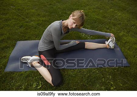 Mid adult woman practicing yoga in park View Large Photo Image Stock Photo - Mid adult woman practicing yoga in park. Fotosearch