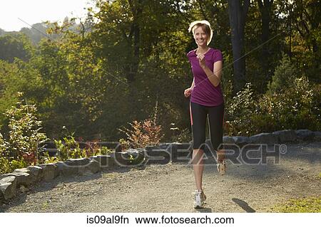 Mid adult woman running in park View Large Photo Image Picture - Mid adult woman running in park. Fotosearch