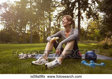 Mid adult woman sitting in park taking exercise break View Large Photo Image Stock Photo - Mid adult woman sitting in park taking exercise break. Fotosearch