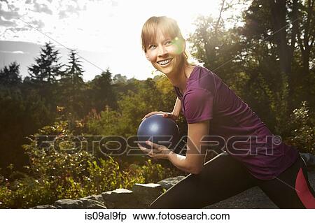 Mid adult woman using exercise ball in park View Large Photo Image Stock Photography - Mid adult woman using exercise ball in park. Fotosearch