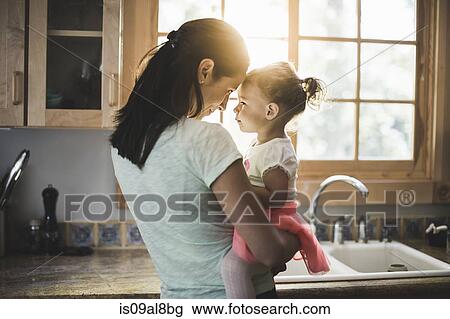 Mother and daughter playing in kitchen View Large Photo Image Stock Image - Mother and daughter playing in kitchen. Fotosearch