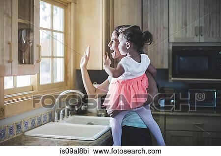Mother and daughter playing in kitchen View Large Photo Image Stock Image - Mother and daughter playing in kitchen. Fotosearch