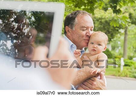 Over shoulder portrait of grandfather and baby granddaughter taken on digital tablet View Large Photo Image Stock Image - Over shoulder portrait of grandfather and baby granddaughter taken on digital tablet. Fotosearch