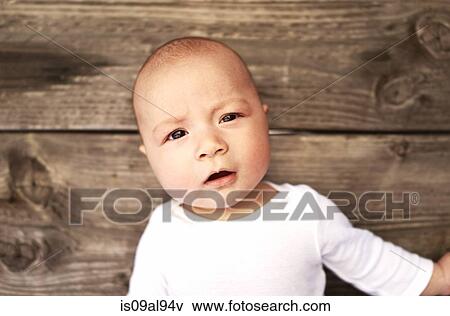 Stock Photo - Overhead portrait of baby boy on wooden floor. Fotosearch