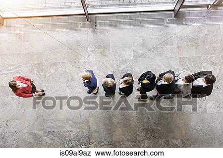 Overhead view of business team in a row in front of boss View Large Photo Image Stock Photo - Overhead view of business team in a row in front of boss. Fotosearch