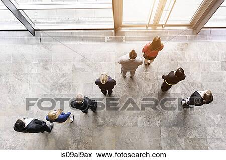 Stock Photo - Overhead view of business team looking out of office window. Fotosearch