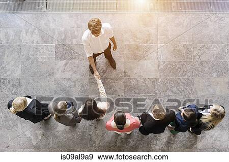 Stock Photo - Overhead view of business team meeting client. Fotosearch