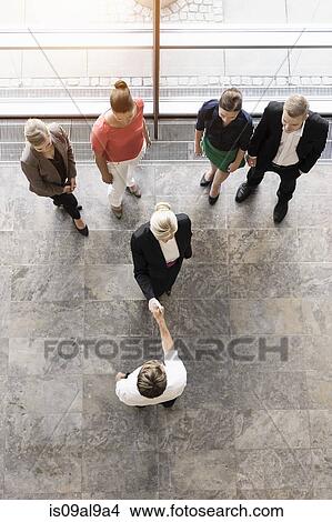 Picture - Overhead view of businesswomen and team meeting client. Fotosearch
