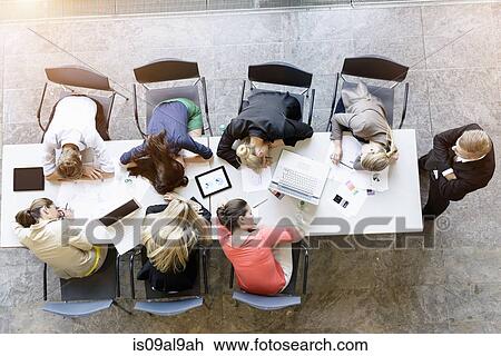 Overhead view of exhausted business team leaning on desk in office View Large Photo Image Stock Image - Overhead view of exhausted business team leaning on desk in office. Fotosearch
