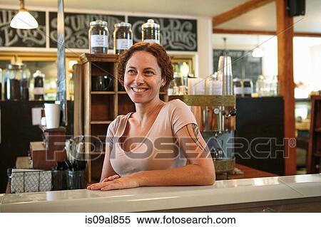 Stock Photography - Portrait of female shop assistant at counter in country store cafe. Fotosearch