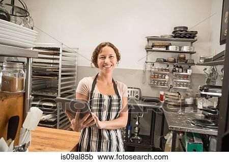 Portrait of female shop assistant with digital tablet in kitchen at country store View Large Photo Image Stock Image - Portrait of female shop assistant with digital tablet in kitchen at country store. Fotosearch