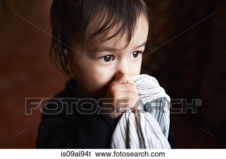 Stock Photograph - Portrait of male toddler holding up comfort blanket to face. Fotosearch