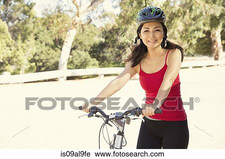 Portrait of mature female cyclist in park View Large Photo Image Stock Image - Portrait of mature female cyclist in park. Fotosearch