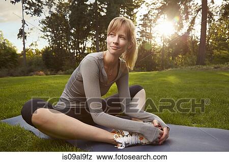 Portrait of mid adult woman practicing yoga in park View Large Photo Image Stock Photo - Portrait of mid adult woman practicing yoga in park. Fotosearch