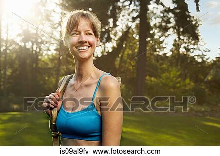 Portrait of smiling female runner in park View Large Photo Image Stock Photo - Portrait of smiling female runner in park. Fotosearch