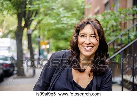 Stock Photography - Portrait of smiling mature woman on city street. Fotosearch