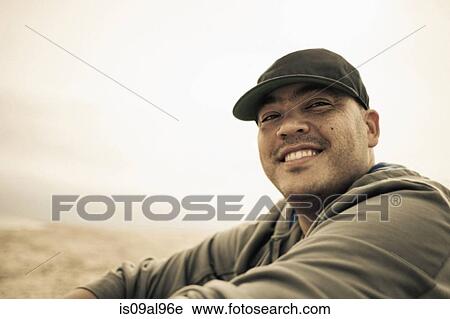 Stock Image - Portrait of smiling mid adult man on beach, Truro, Massachusetts, Cape Cod, USA. Fotosearch