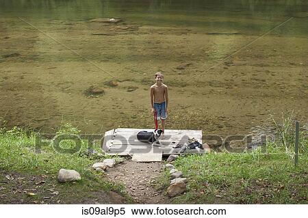 Stock Photography - Portrait of teenage boy standing on pier, Canton, North Carolina, USA. Fotosearch
