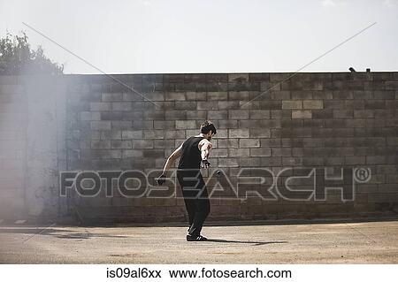 Rear view of young male handball player hitting ball against wall View Large Photo Image Stock Photo - Rear view of young male handball player hitting ball against wall. Fotosearch
