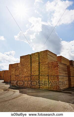 Stock Image - Rows of stacked wooden planks in timber yard. Fotosearch