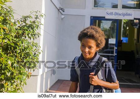 Stock Photograph - Schoolgirl walking into school. Fotosearch