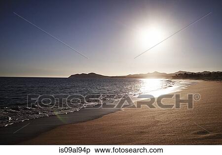 Stock Photography - Silhouetted view of coastline and empty beach, Cabo, Mexico. Fotosearch