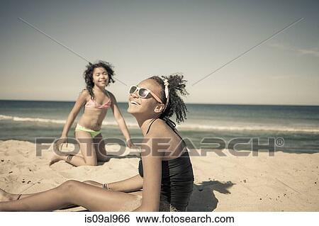 Stock Photograph - Sisters playing on beach, Truro, Massachusetts, Cape Cod, USA. Fotosearch