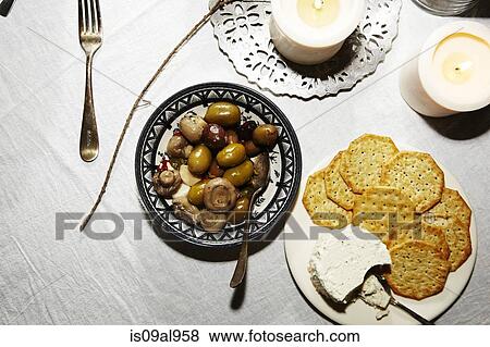Snack meal of olives, mushrooms, brie and crackers on table View Large Photo Image Stock Photo - Snack meal of olives, mushrooms, brie and crackers on table. Fotosearch