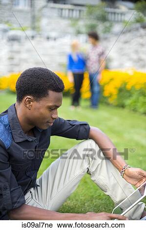 Stock Image - Student holding digital tablet. Fotosearch