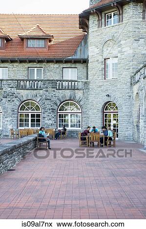 Stock Photo - Students sitting on patio outside university building. Fotosearch