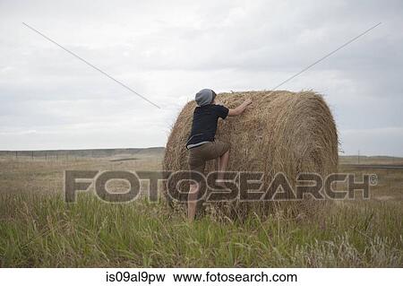 Teenage boy climbing on haystack, South Dakota, USA View Large Photo Image Stock Photo - Teenage boy climbing on haystack, South Dakota, USA. Fotosearch