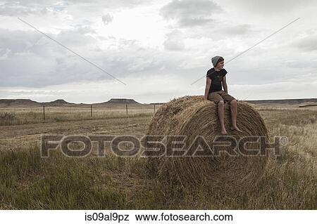 Teenage boy sitting on haystack in field, South Dakota, USA View Large Photo Image Stock Photo - Teenage boy sitting on haystack in field, South Dakota, USA. Fotosearch