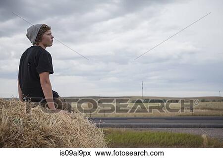 Teenage boy sitting on haystack, South Dakota, USA View Large Photo Image Stock Photo - Teenage boy sitting on haystack, South Dakota, USA. Fotosearch
