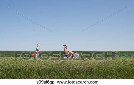 Teenage girl riding tricycle and boy on inflatable hopper View Large Photo Image Stock Photography - Teenage girl riding tricycle and boy on inflatable hopper. Fotosearch