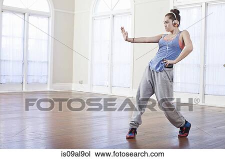 Stock Image - Teenage girl warming up with alternative dance in ballet school. Fotosearch