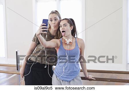 Stock Photography - Two teenage girls taking smartphone selfie in ballet school. Fotosearch