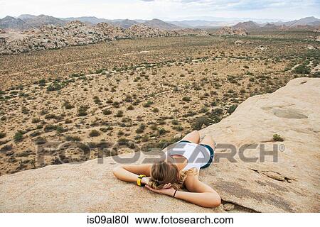 Stock Image - Woman taking break on mountain, Joshua Tree National Park, California, US. Fotosearch