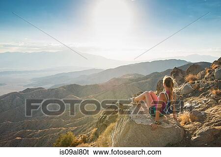 Woman taking break on mountain, Joshua Tree National Park, California, US View Large Photo Image Stock Photograph - Woman taking break on mountain, Joshua Tree National Park, California, US. Fotosearch