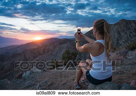 Woman taking photo of mountain, Joshua Tree National Park, California, US View Large Photo Image Stock Photo - Woman taking photo of mountain, Joshua Tree National Park, California, US. Fotosearch